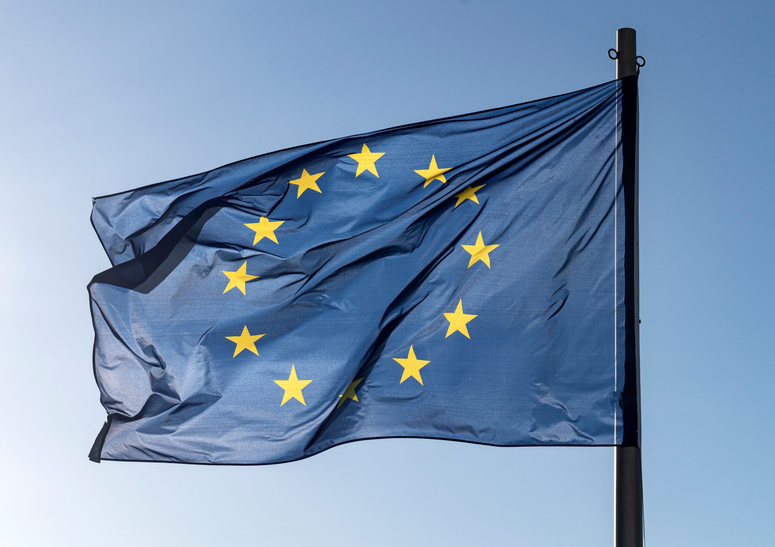 Flag of EU flying in the wind with a blue sky background.

country, land, european, union, europe,